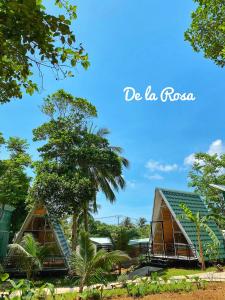 a view of two houses with trees in the background at Homestay De la Rosa - Côn Đảo in Con Dao
