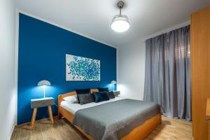 ein blaues Schlafzimmer mit einem Bett und einer blauen Wand in der Unterkunft Ellanna in Mlini