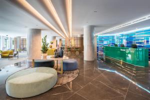 a lobby with a table and chairs in a building at Barceló Costa Vasca in San Sebastián