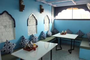 a room with two tables and a blue wall at Moustache Jodhpur in Jodhpur