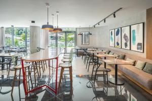 a restaurant with tables and chairs and windows at Barceló Costa Vasca in San Sebastián