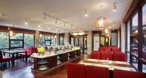 un restaurant avec des chaises rouges et un bar avec des verres à vin dans l'établissement Guilin Zizhou Panorama Resort, à Guilin