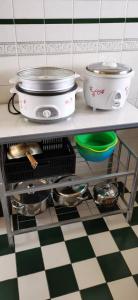 a kitchen counter with pots and pans on a checkered floor at My Home Apartment - Villa Dahlia Apartment in Cameron Highlands