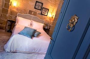 a bedroom with a bed with two pillows on it at Lulu Boutique Hotel in Żebbuġ