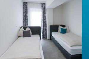 1 dormitorio con 2 camas y ventana en Motel24seven en Bruck an der Mur