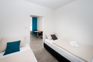 a white room with a bed and a table at Motel24seven in Bruck an der Mur