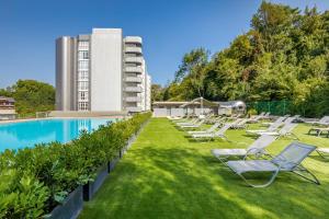 uma piscina com espreguiçadeiras e um edifício em Barceló Costa Vasca em San Sebastián