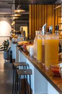 a counter with several glasses of orange juice on it at CPH Studio Hotel in Copenhagen