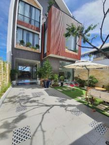 a building with a patio with a table and an umbrella at VILLADECELIA in Da Lat