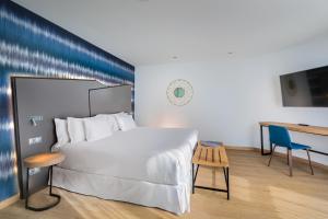 a bedroom with a large white bed and a desk at Barceló Costa Vasca in San Sebastián