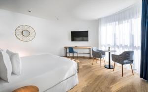 a hotel room with a bed and a table and chairs at Barceló Costa Vasca in San Sebastián
