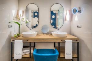 a bathroom with two sinks and two mirrors at Barceló Costa Vasca in San Sebastián