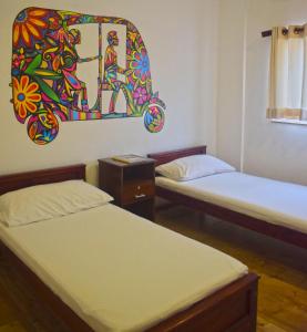 City Beds Colombo في كولومبو: غرفة بسريرين ولوحة على الحائط