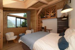 a bedroom with a bed and a large window at Chalet nature et design in Servoz +68 photos