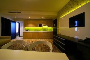a living room with a kitchen with green lighting at Art Hotel Szeged in Szeged