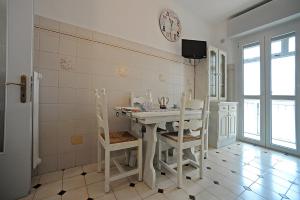 都靈的住宿－Appartamento con vista in zona Lingotto by Wonderful Italy，厨房配有桌椅和墙上的时钟