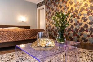 una mesa de café de cristal con un jarrón de flores. en Hotel Peregrin en Český Krumlov