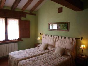 a bedroom with a bed and two windows at Agroturismo El Mirador de la Cigüeña in Cabanillas del Monte