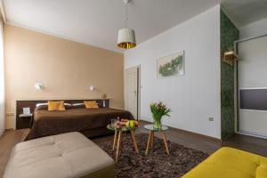 een slaapkamer met een bed, een bank en een tafel bij Hotel Peregrin in Český Krumlov