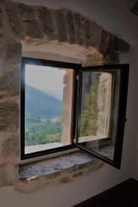 una finestra con vista su un muro di pietra di B&B Le Fate a Sonnino