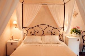een slaapkamer met een groot wit bed en een baldakijn bij Casa Contessa in Livade