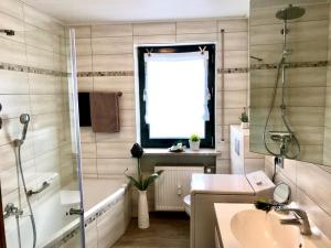 a bathroom with a tub and a sink and a bath tubermott at Ferienhaus 1 An der Rodach in Steinwiesen +25 photos