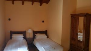 1 dormitorio con 2 camas, tocador y espejo en El llagar, en Vis