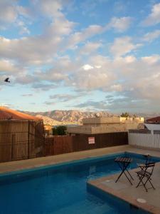 a swimming pool with two chairs and a view of the mountains at Blue Lagoon with Pool in Eilat