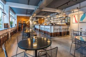 a restaurant with tables and chairs and a bar at CPH Studio Hotel in Copenhagen