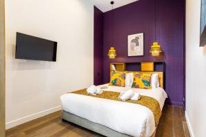 Un dormitorio con una cama grande con una pared morada. en Appartement indépendant-2 chambres !!Parc des expositions, en París
