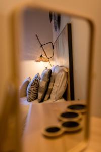 a reflection of a bed with a lamp and pillows at Anthemion Suites and Villas in Nafplio