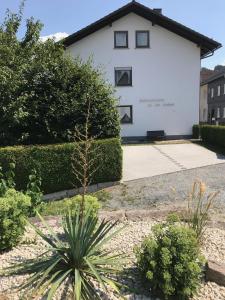 a white house with a plant in front of it at Ferienhaus 1 An der Rodach in Steinwiesen