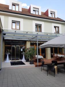 a building with a patio with tables and chairs at LONDON Boutique hotel & Restaurant in Trnava
