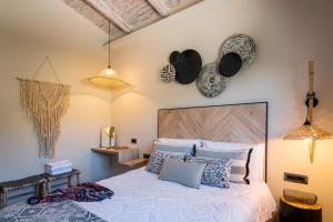 ein Schlafzimmer mit einem großen Bett und zwei Hüten an der Wand in der Unterkunft Anthemion Suites and Villas in Nafplio