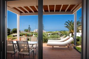 a patio with a table and chairs and a couch at Artemis Village Apartments & Studios in Stavros