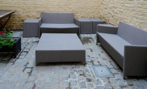 a row of benches sitting on a brick patio at Apartments Ypres in Ypres