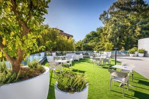 a patio with tables and chairs and a tree at Barceló Costa Vasca in San Sebastián