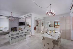 eine weiße Küche mit einem Tisch und einem Esszimmer in der Unterkunft Windmill Villa in Kalivia Poligirou