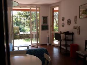 a living room with a couch and a sliding glass door at Casa Berizzi Mare - Arenzano Pineta in Arenzano