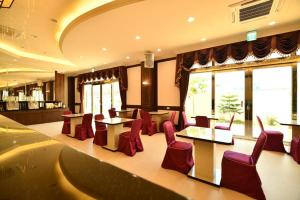 a restaurant with red chairs and tables and windows at Chuan Cheng Castle in Magong