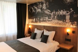 a bedroom with a bed with a picture on the wall at Hotel Botteltje in Ostend