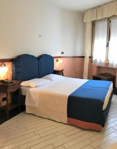 a bedroom with a large bed with a blue headboard at Hotel San Felice in Bologna