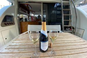 a bottle of wine and two wine glasses on a table at Italian Superyacht Bianca Lucida in London