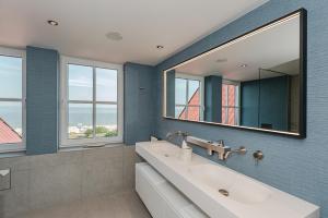 a bathroom with a sink and a mirror at Strandhotel Ostende Adults Only in Ahlbeck +109 photos