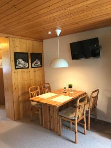 una sala da pranzo con tavolo e sedie in legno di Ferienwohnung Résidence Sonnegg - Hein a Zweisimmen