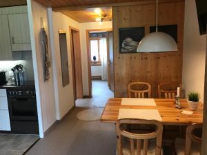 una cucina e una sala da pranzo con tavolo e sedie in legno di Ferienwohnung Résidence Sonnegg - Hein a Zweisimmen