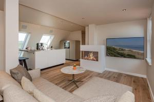 a living room with a couch and a fireplace at Strandhotel Ostende in Ahlbeck