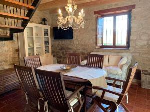 comedor con mesa, sillas y lámpara de araña en Casa Rural El Pajarcillo en Moriana