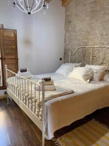 a bedroom with a white bed and a chandelier at Casa Rural El Pajarcillo in Moriana