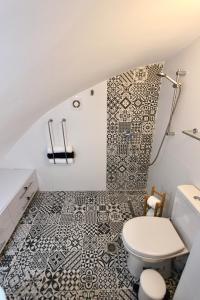 a bathroom with a toilet and a tiled wall at St. John Apartment in Jerusalem